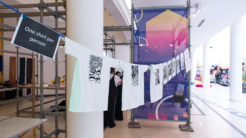 Photograph showing t-shirts hung up on a line in a studio