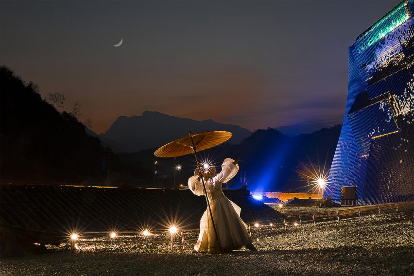 Visualisation showing figure with parasol in nighttime setting with pavilion behind