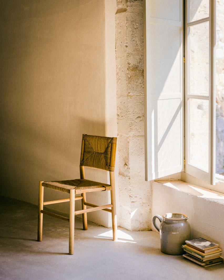 Photograph showing chair by window in rustic interior