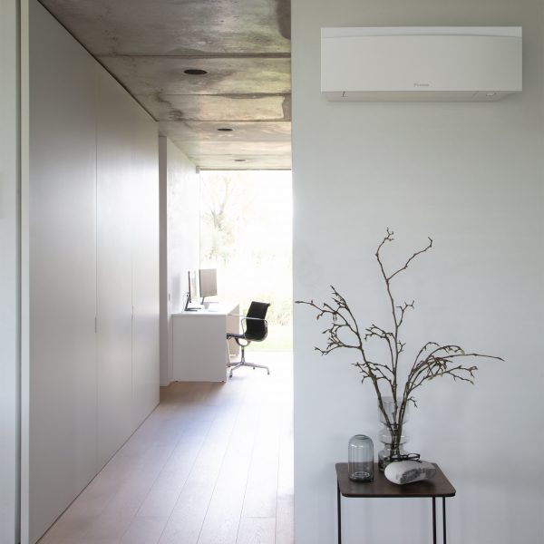 White Emura unit by Daikin in a hall with a small table