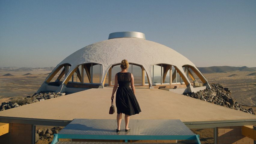 A character on set of Don't Worry Darling in front of a domed building