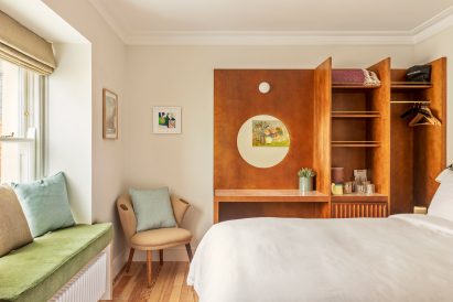 Bed, chair and vanity unit in Fort Road Hotel