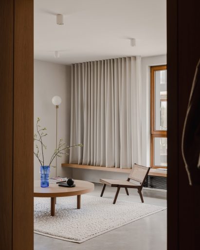 View into living room of The Hideaway Home apartment with low timber coffee table and armchair