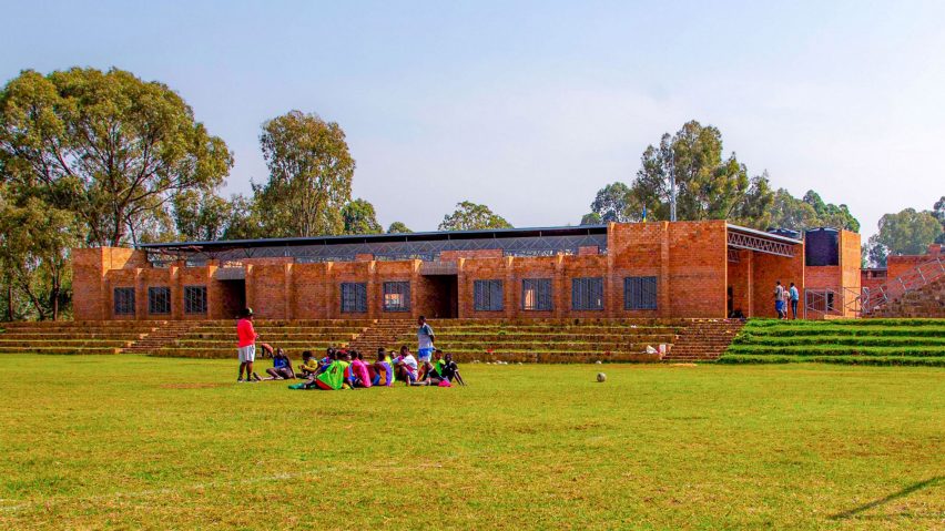 Exterior image of people on a grassy field in front of the Learning + Sports Center