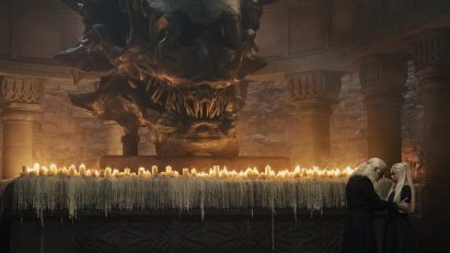 A large dragon head above an altar with candles