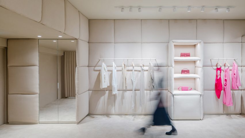 A woman walking through a Jacquemus store interior