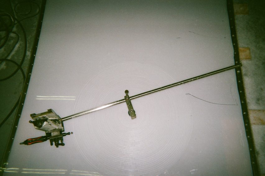 Process photo of a machine cutting circular facets into a sheet of polycarbonate