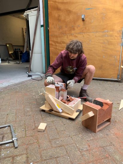 Jelle Seegers removes a metal object from a sand mould