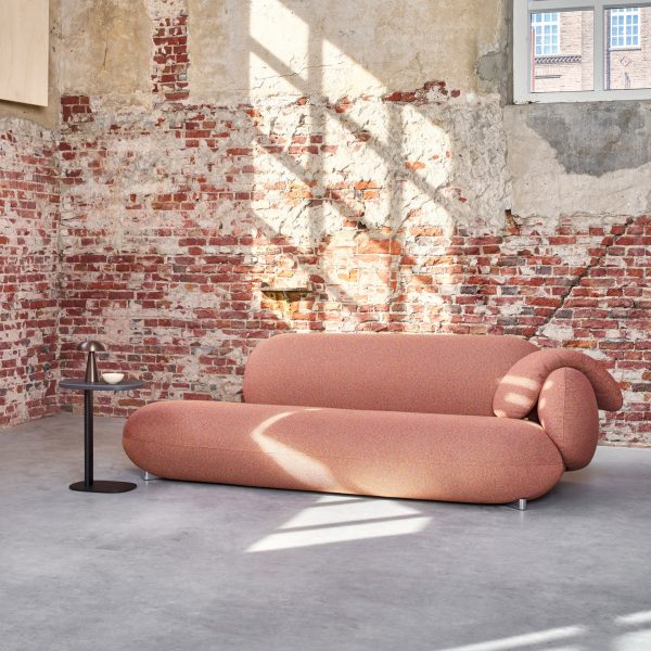 Pink LXR16 sofa by Leolux LX in room with distressed brick walls