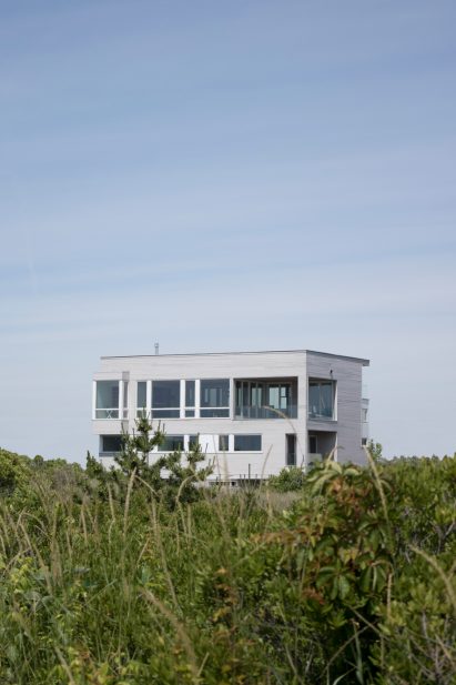 A grey cube shaped house on grass