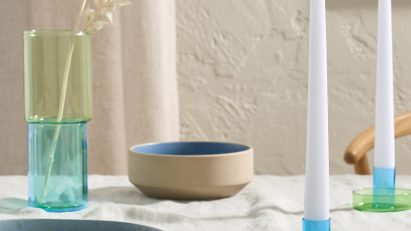Colourful candlesticks on white cloth