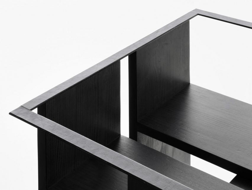 Detail of black chair on white plinth in front of white background