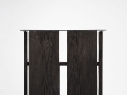 Detail of black chair on white plinth in front of white background