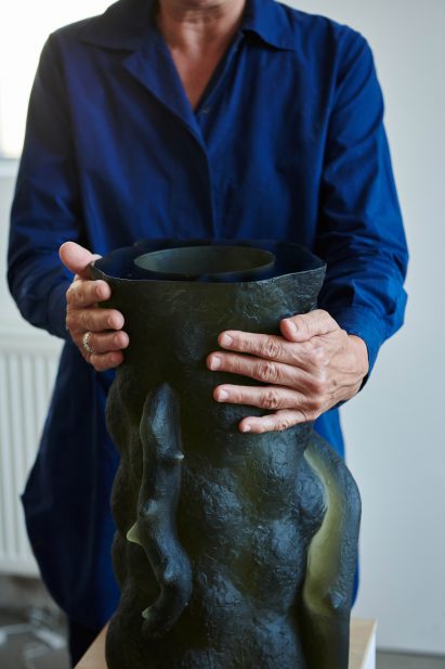 Photograph of artist with sculpture