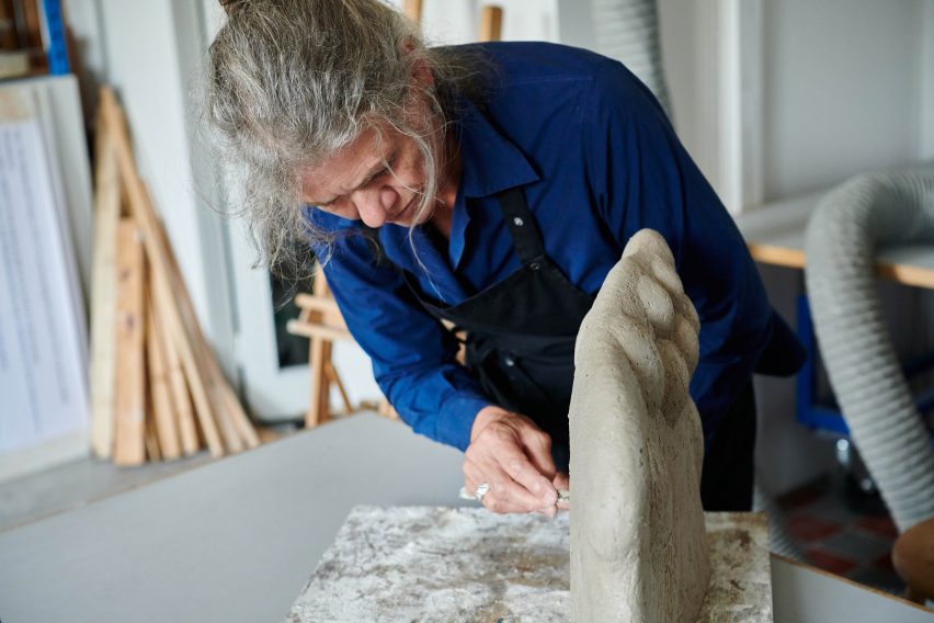 Photograph of artist with sculpture