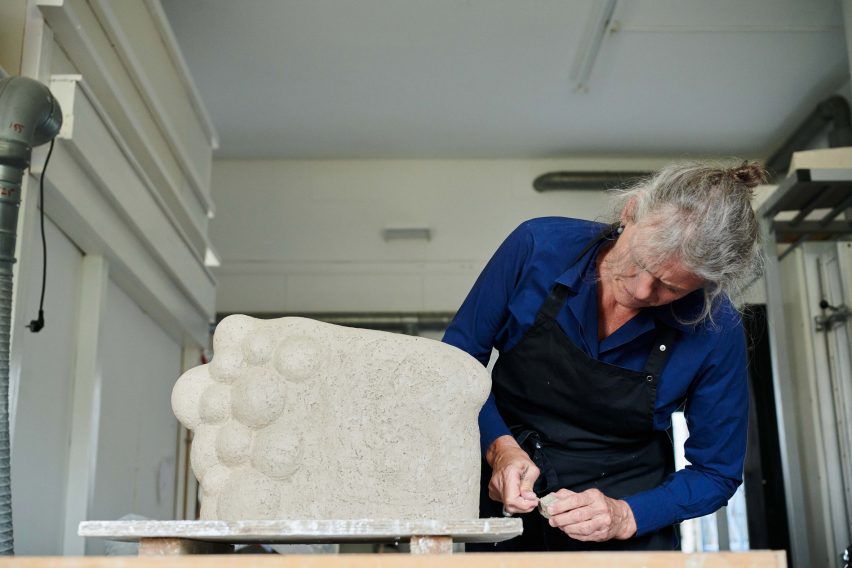 Photograph of artist with sculpture
