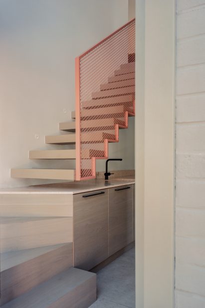 Interior image of a salmon pink balustrade at Grid House