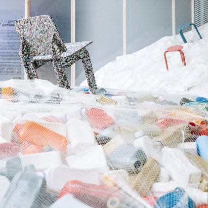 Furniture placed on piles of waste at Piles of waste at Nothing is Possible exhibition by Potato Head and OMA