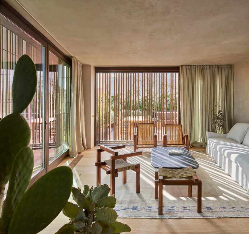 Wood screens and green courtyards define apartment block in Mallorca by OHLAB