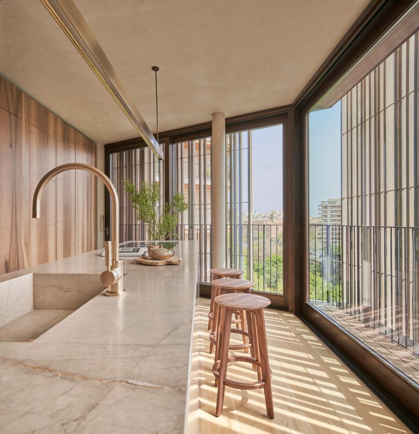 Wood screens and green courtyards define apartment block in Mallorca by OHLAB