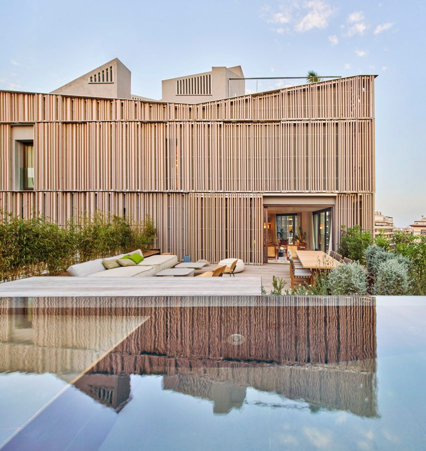 Wood screens and green courtyards define apartment block in Mallorca by OHLAB