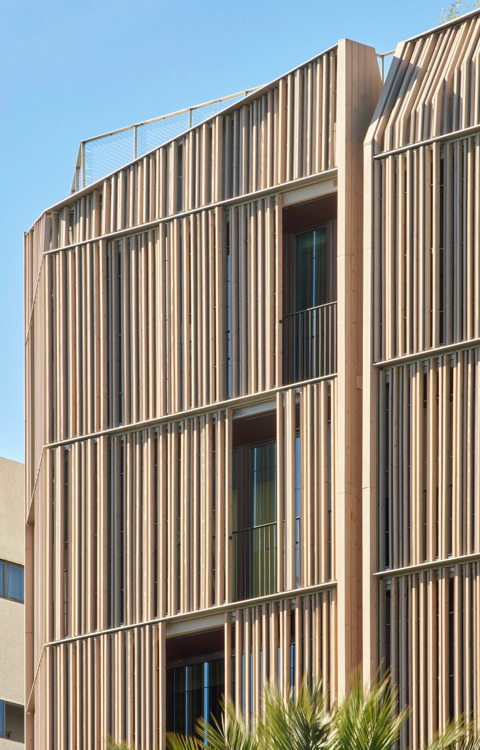 Wood screens and green courtyards define apartment block in Mallorca by OHLAB