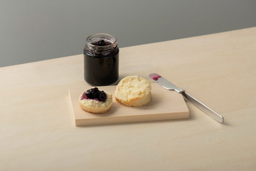 Oku knife by Kathleen Reilly on the edge of a wood chopping board with jam and scones