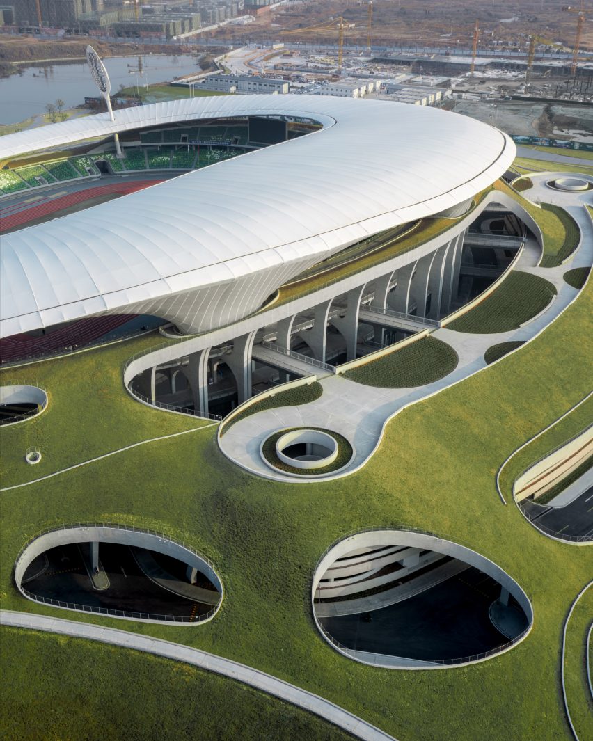 Overview of white stadium submerged into green hill