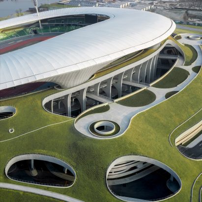 White stadium emerging from green hill