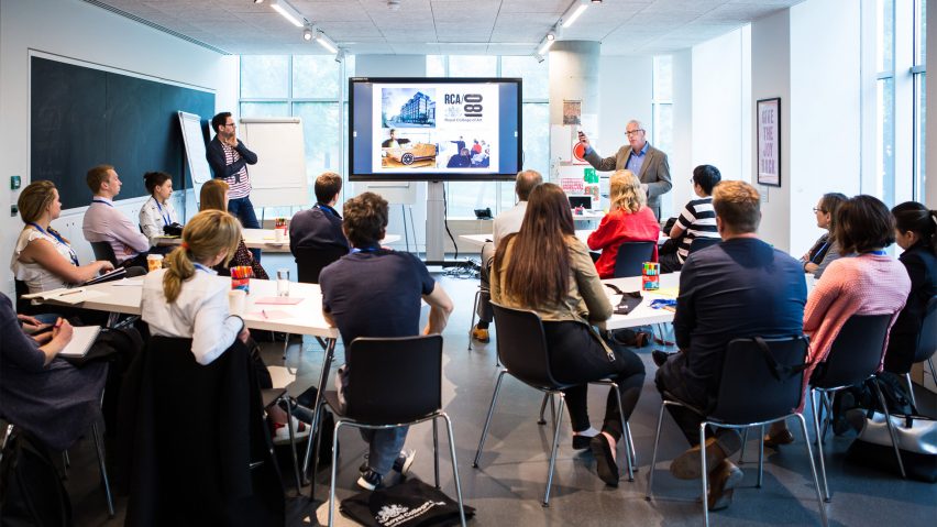 People in a class room looking towards a digital screen