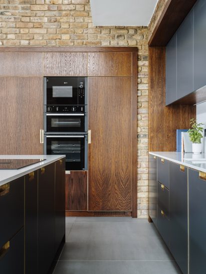 Kitchen area with wooden and dusky blue cabinets