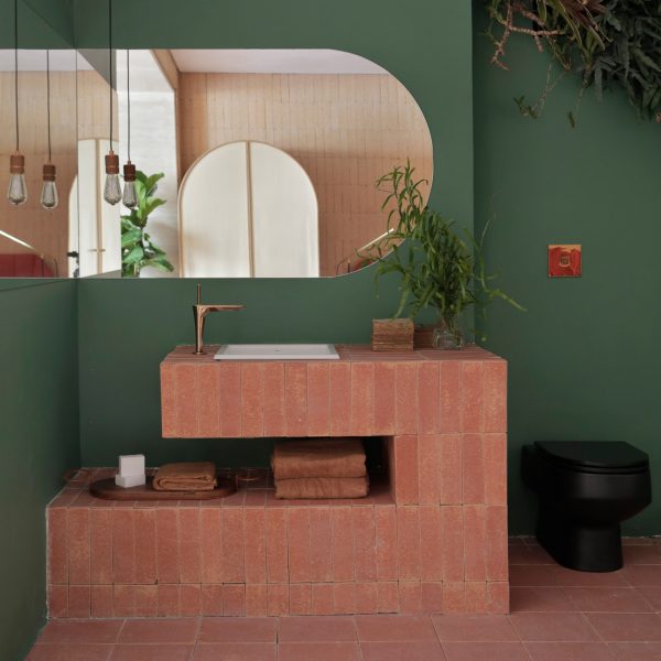 A red brick sink in a green bathroom