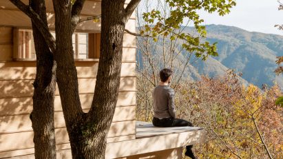 Person on terrace of wooden cabin