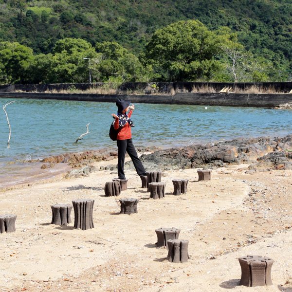 Person beside coastline seats in Hong Kong