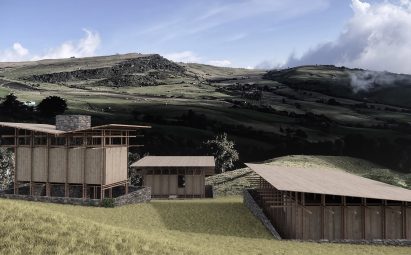 Three barn-like buildings an a green field