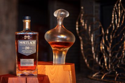 A photograph of a decanter and whisky bottle besides it
