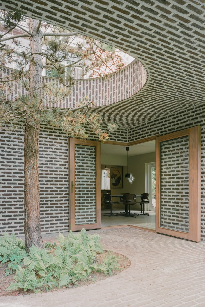 Brick extension opens rural Dutch home out towards a forested garden