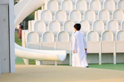 Boy outside a white play object with a slide