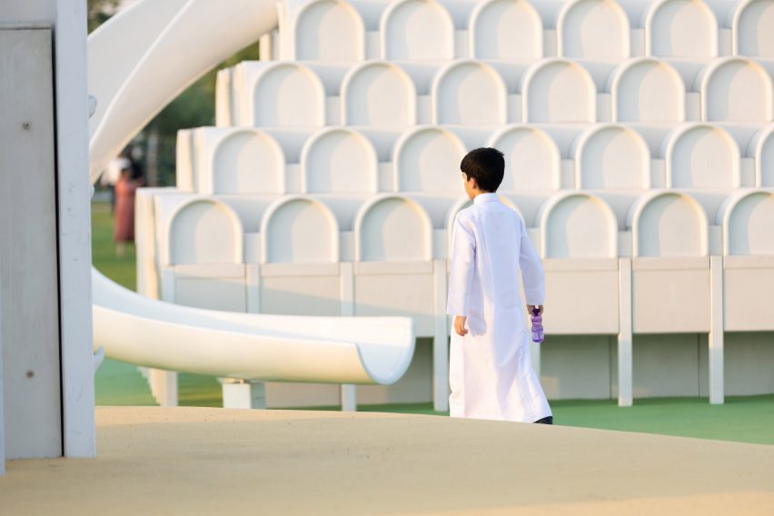 Boy outside a white play object with a slide