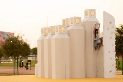 A girl on a white climbing wall in Doha