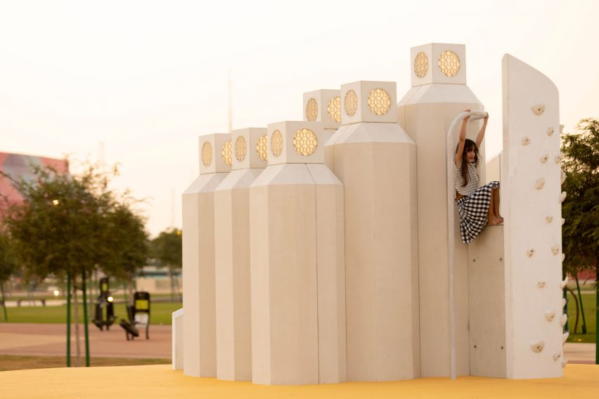 A girl on a white climbing wall in Doha