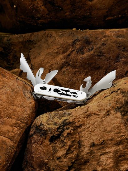 White Swiss Army knife with print of black stones 