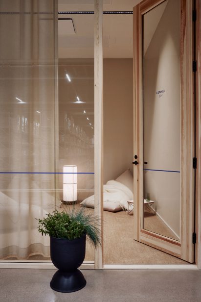 Photo of a timber-framed glass office door with warm light and a beige beanbag with throw rug in one corner