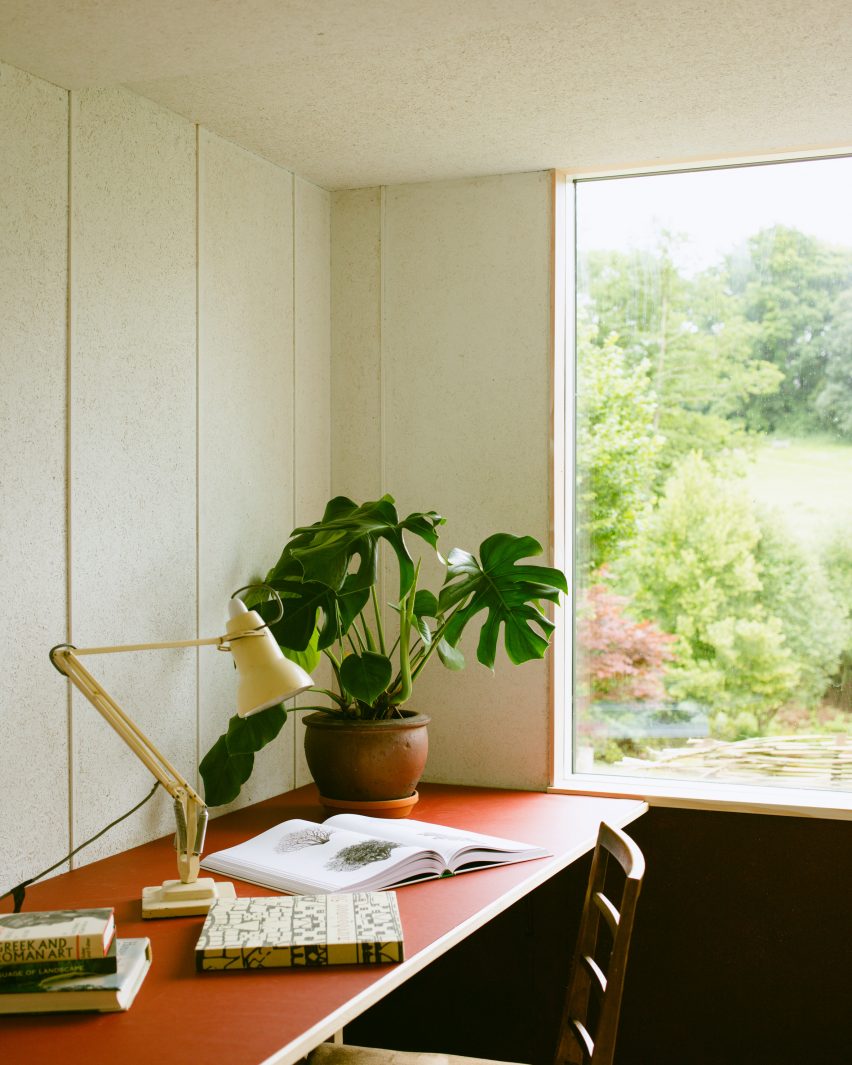 Interior of The Garden Studio with in-built red desk, lamp and plant