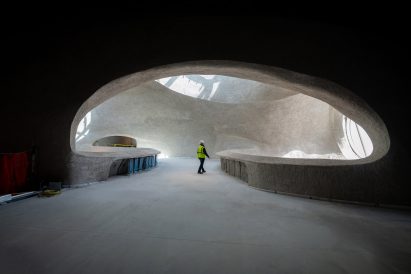 Construction worker walking in halls of Gilder Center under construction