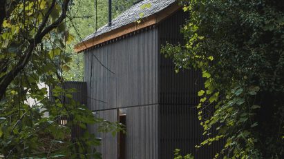 Looking through trees at exterior of Granary House guesthouse by MIMA Housing