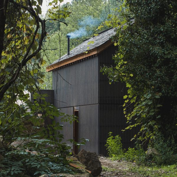 Looking through trees at exterior of Granary House guesthouse by MIMA Housing