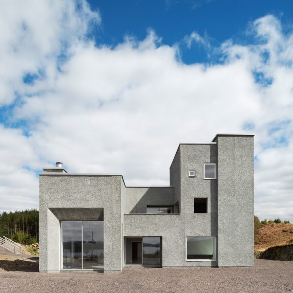 Grey pebble dash house with glazed double doors and large window