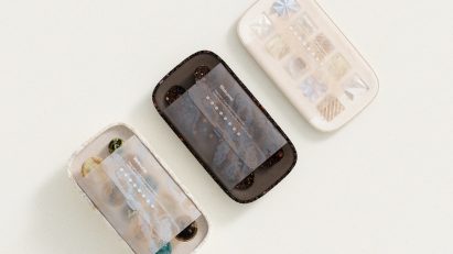 Rendering of three boxes of Keia subscription edibles by Layer with paper sleeves reading "Welcome. Keep track of your microdosing schedule. Highlighted numbers are dose days throughout the month."