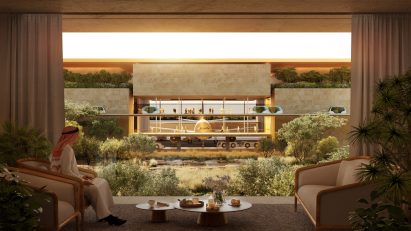 Man sitting at table in front of window overlooking airport